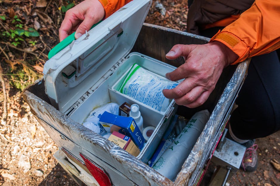 Hiker opening a first aid kit during an outdoor trail adventure